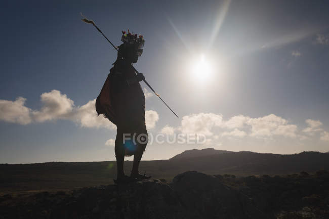 Massai-Mann steht an einem sonnigen Tag mit Stock auf dem Land — Stockfoto