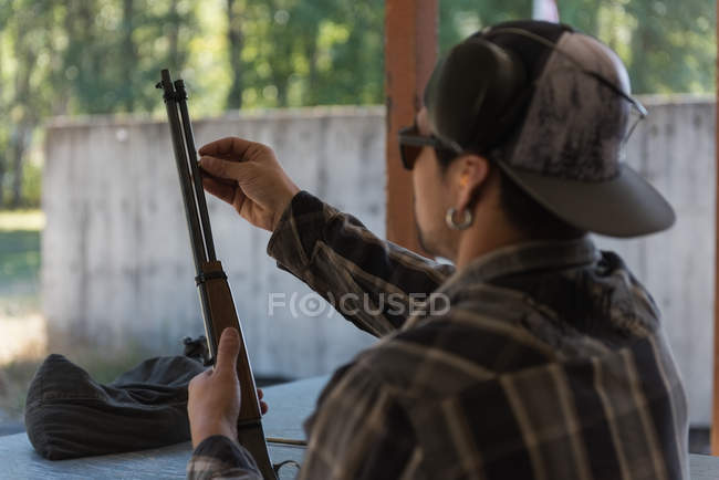 Gros plan de l'homme caucasien vérifiant fusil de chasse — Photo de stock