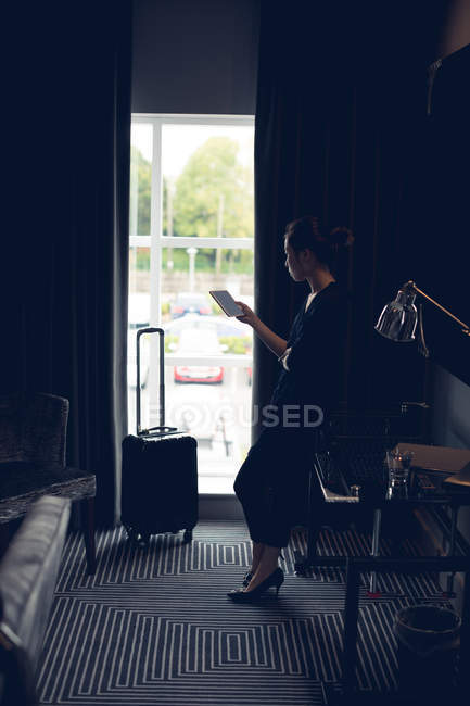 Tablet digital mulher atenciosa no quarto de hotel — Fotografia de Stock