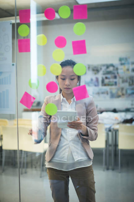 Executivo feminino usando tablet digital no escritório moderno — Fotografia de Stock