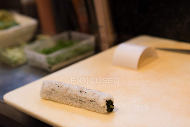 Рулонні суші тримають на рубаній дошці в ресторані — стокове фото