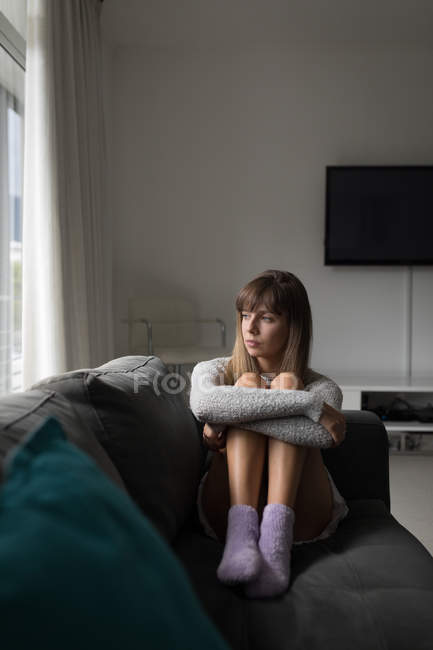Femme réfléchie se détendre dans le salon à la maison — Photo de stock