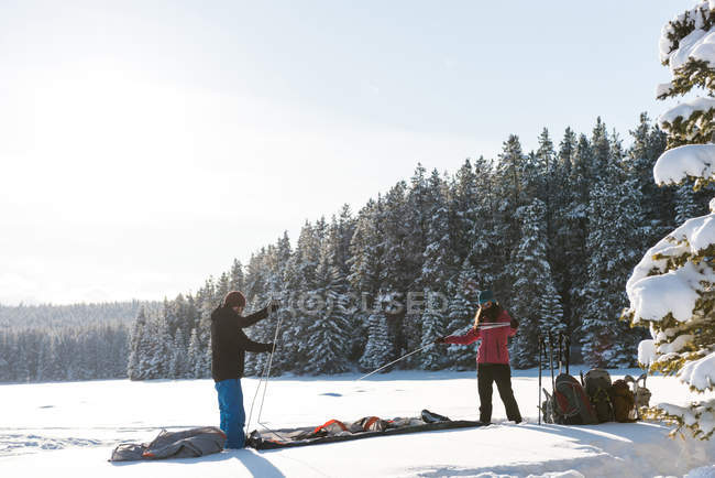 Pareja tienda de campaña en el paisaje nevado durante el invierno . - foto de stock