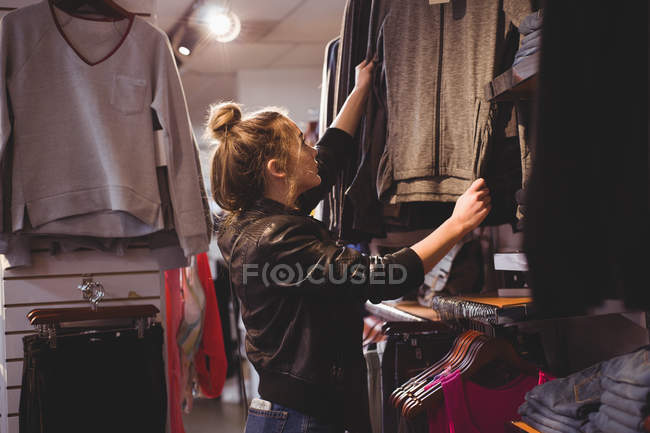 Schönes Mädchen kauft Kleidung in Einkaufszentrum ein — Stockfoto