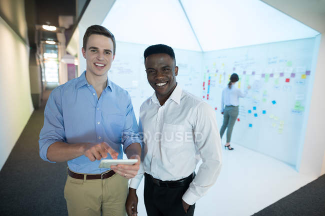 Retrato de ejecutivos masculinos usando tableta digital en oficina futurista - foto de stock
