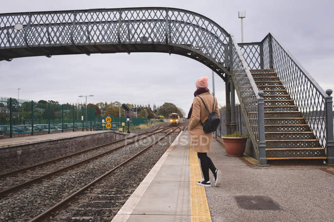 Visão traseira da mulher à espera de trem na estação ferroviária — Fotografia de Stock