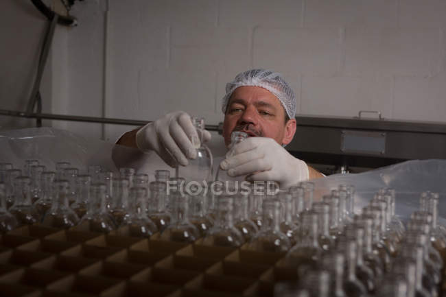 Чоловічий працівник розміщення порожні пляшки в стійці на заводі — стокове фото