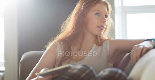 Mujer usando tableta digital en la sala de estar en casa - foto de stock