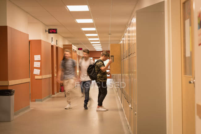 Estudiantes universitarios caminando por el pasillo de la universidad - foto de stock