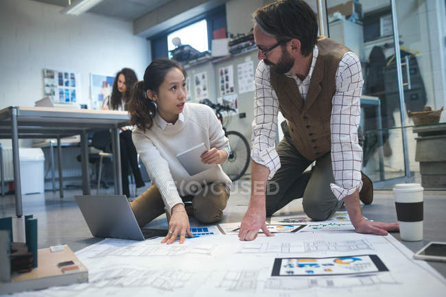 Виконавці обговорюють план в сучасному офісі — стокове фото