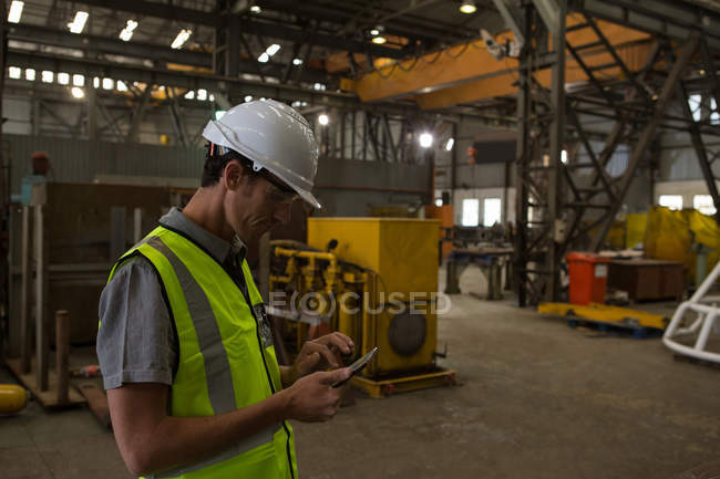 Schiffsingenieur nutzt Handy in Werkstatt — Stockfoto