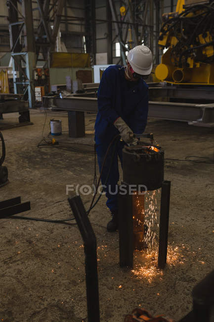 Welder repairing vessel part in workshop — Stock Photo