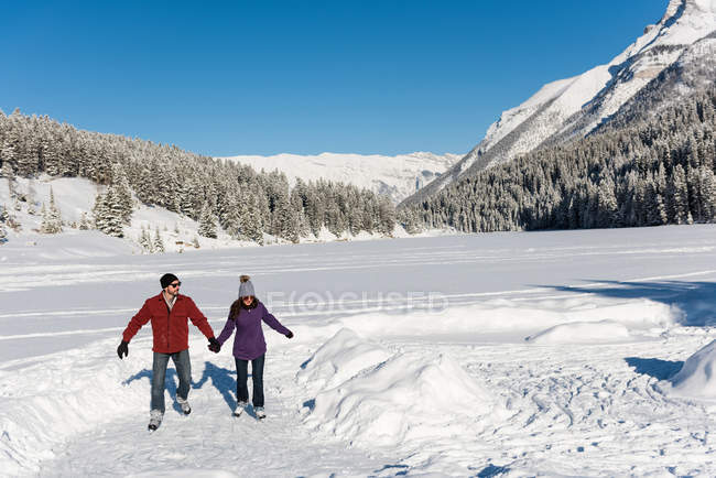 Couple skating together in snowy landscape during winter. — Stock Photo