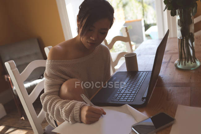 Mujer joven trabajando en casa - foto de stock