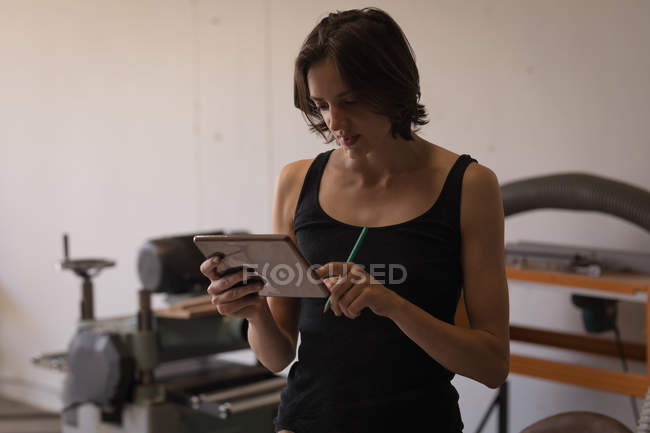 Young female artisan using digital tablet in workshop. — Stock Photo