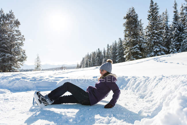 Mulher caindo enquanto patina na paisagem nevada durante o inverno . — Fotografia de Stock