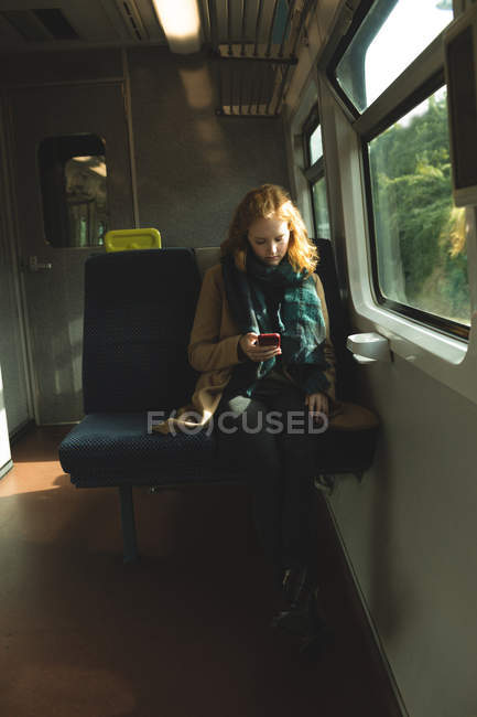 Junge Frau benutzt Handy während Zugfahrt — Stockfoto