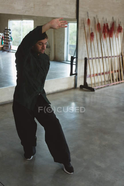 Homme pratiquant le kung fu dans un studio de fitness . — Photo de stock
