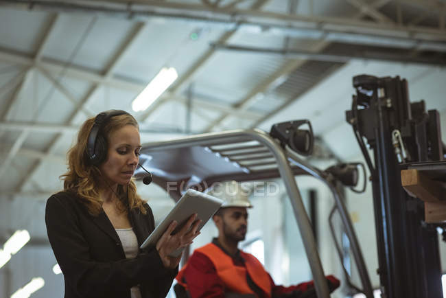 Жінка використовує цифровий планшет на складі заводу — стокове фото