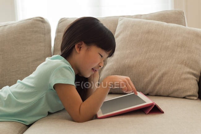 Mädchen nutzt digitales Tablet im heimischen Wohnzimmer — Stockfoto