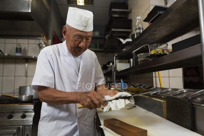 Senior chef che tiene il coltello in cucina in hotel — Foto stock