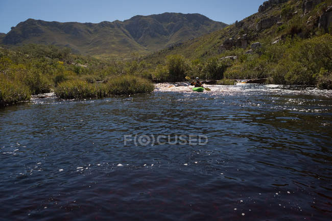 Kayak donna in acqua di fiume di montagna alla luce del sole . — Foto stock