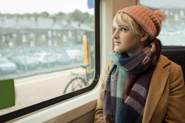 Femme réfléchie en vêtements chauds voyageant en bus — Photo de stock
