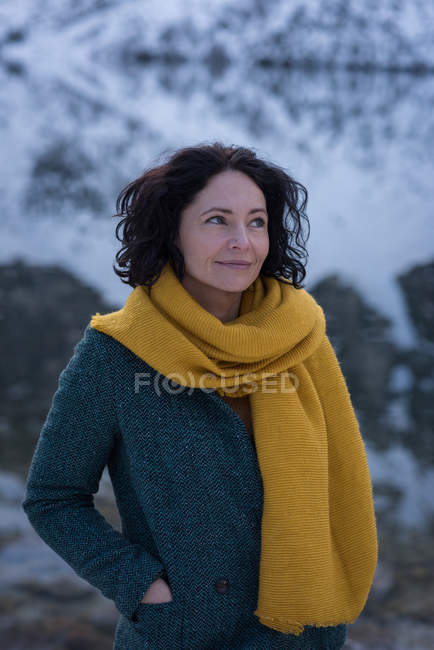 Female hiker standing at lakeside during winter — Stock Photo