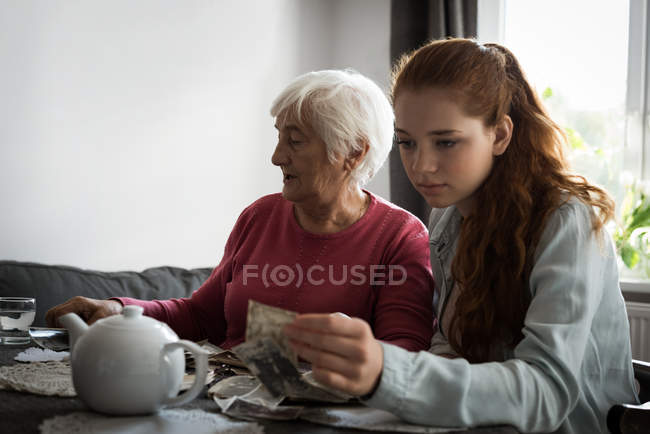 Großmutter und Enkelin sitzen zu Hause im Wohnzimmer zusammen — Stockfoto