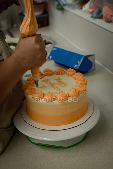 Close-up of woman preparing cake in bakery — Stock Photo