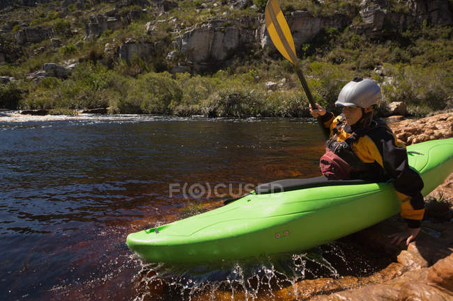 Mulher se preparando para andar de caiaque no rio à luz do sol . — Fotografia de Stock