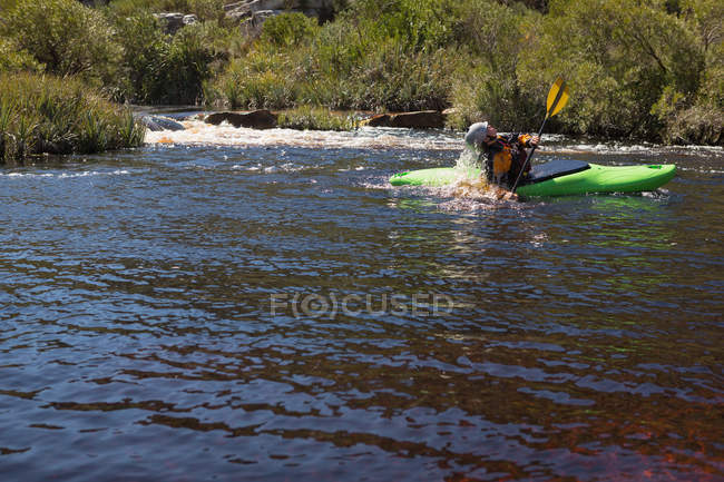 Mujer kayak en agua de río de montaña a la luz del sol . - foto de stock