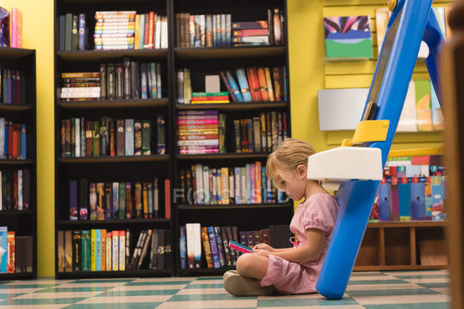 Cute girl reading book in store — Stock Photo