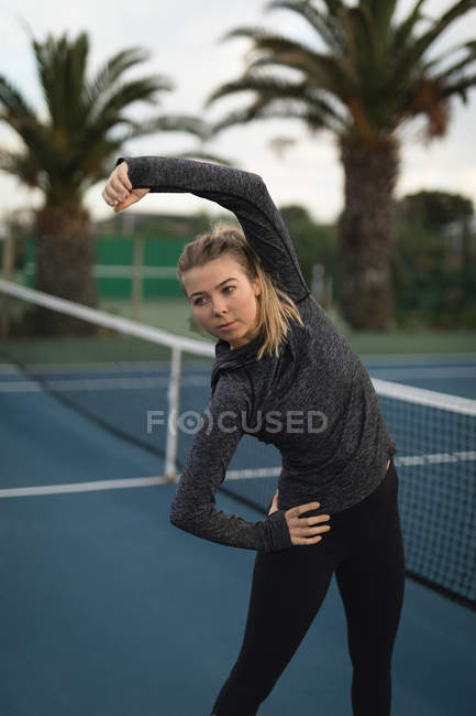 Молодая женщина занимается на теннисном корте — стоковое фото