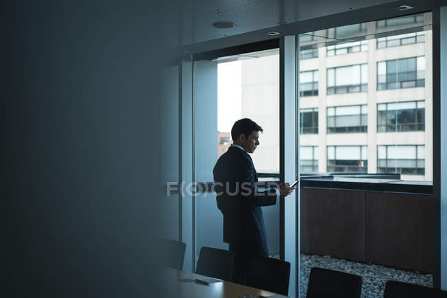 Homme d'affaires utilisant le téléphone portable dans la salle de conférence — Photo de stock