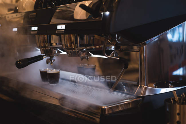 Copos de café mantidos na máquina de café expresso cozido no vapor no café — Fotografia de Stock