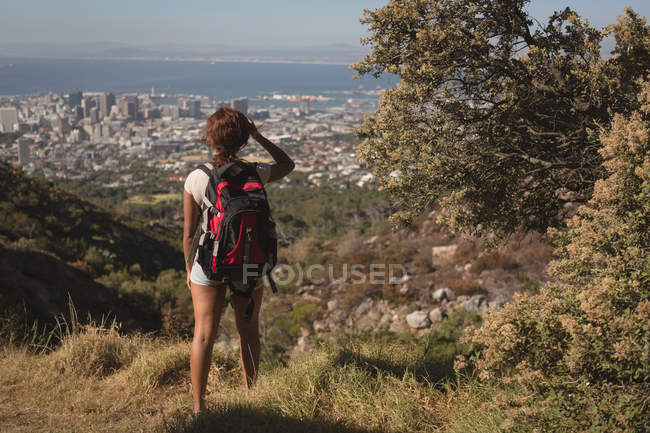 Rückansicht einer Wanderin, die mit Rucksack auf dem Land steht — Stockfoto