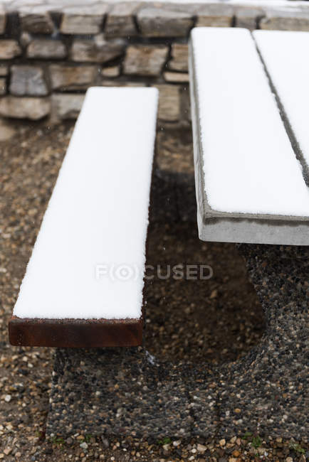 Banco e mesa cobertos de neve durante o inverno — Fotografia de Stock