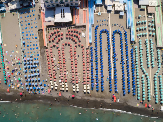 Aerial of Multi colored beach umbrellas at the coast — Stock Photo