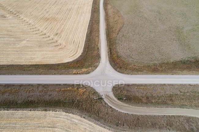 Aerial of empty road passing through wheat field — Stock Photo