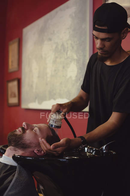 Чоловік миє волосся в перукарні — стокове фото