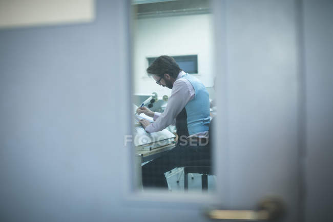 Executive working over drafting table in modern office — Stock Photo