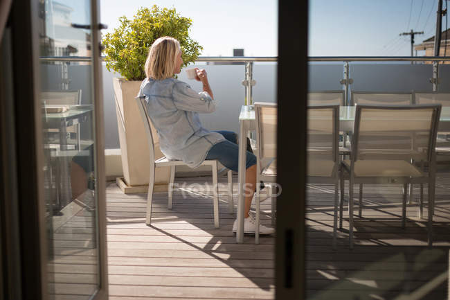 Mujer discapacitada tomando café en el balcón en casa . - foto de stock