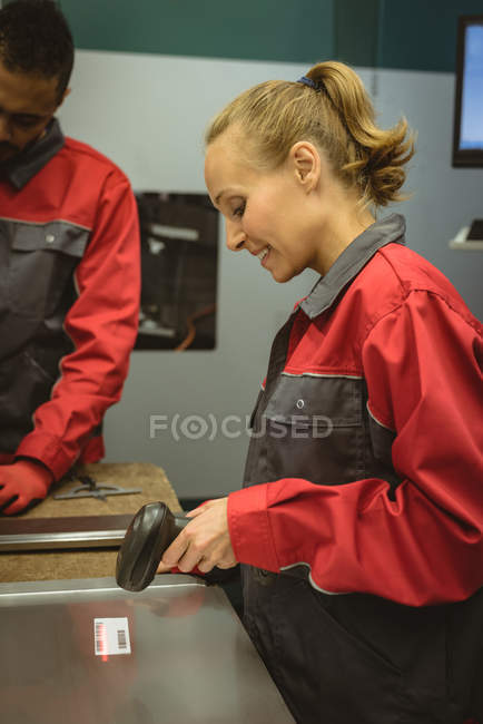 Trabajadora escaneando un código de barras en fábrica - foto de stock
