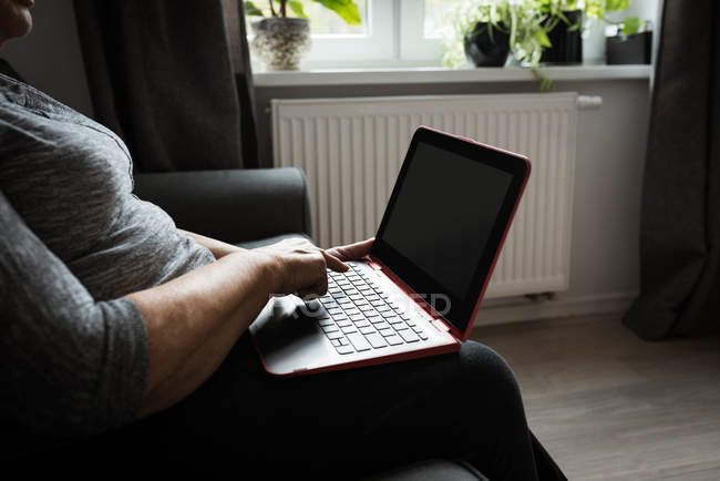 Seniorin benutzt Laptop im Wohnzimmer — Stockfoto