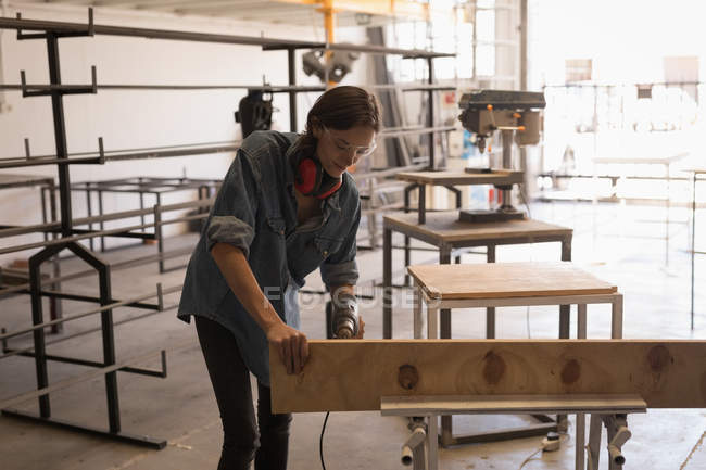 Женщина-ремесленница с помощью сверлильной машины в мастерской . — стоковое фото