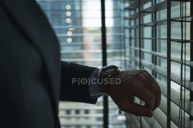 Cropped image of Businessman checking time on wrist watch at hotel — Stock Photo
