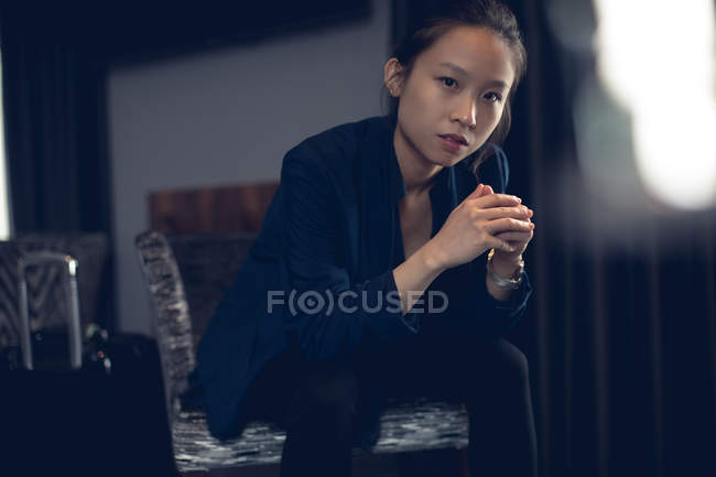 Retrato de la mujer sentada en la habitación del hotel - foto de stock