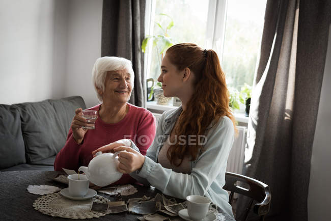 Großmutter und Enkelin interagieren zu Hause miteinander — Stockfoto