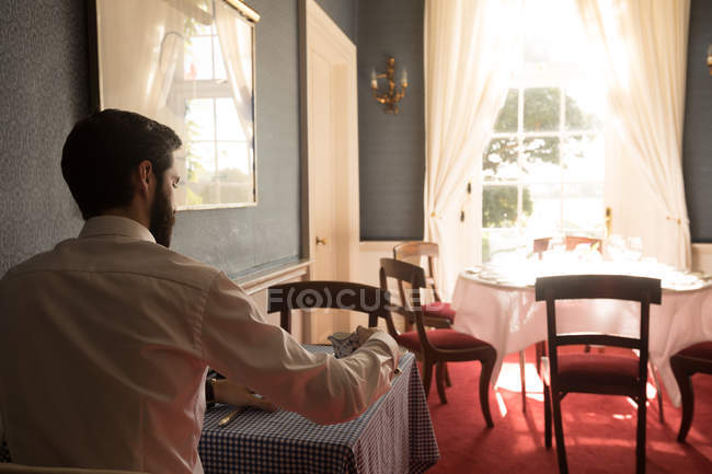 Rear view of groom having tea at table — Stock Photo